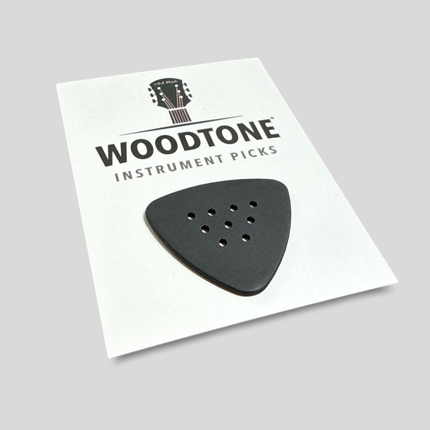 Woodtone instrument pick on a white card with a gray background
