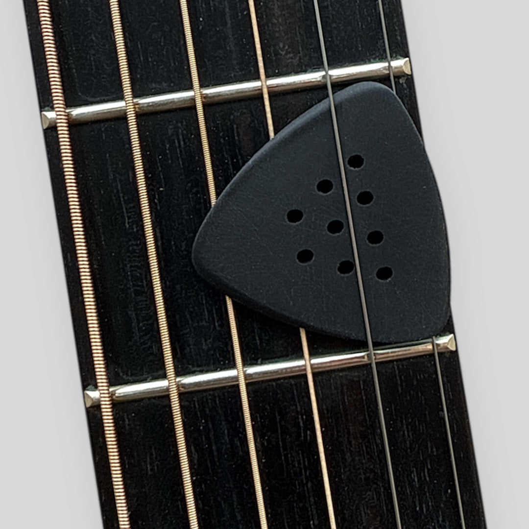 Black guitar pick on a guitar fretboard with white background