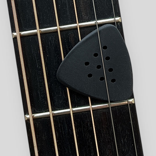 Black guitar pick on a guitar fretboard with white background